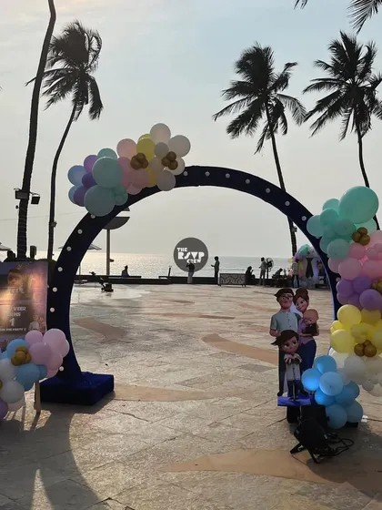 A simple and elegant Frozen-themed arch at a beachside venue, decorated with pastel balloons.