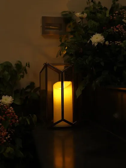 A geometric lantern casting a warm glow in a dimly lit corner. We use various styles of lanterns to complement the specific theme of each event.