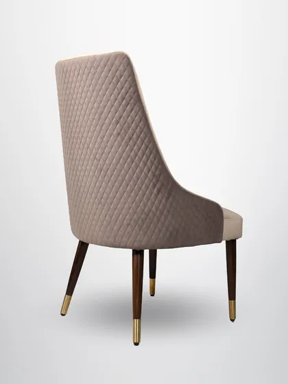 This dining chair is all about quiet class. The back features a subtle diamond quilting, and the tapered wooden legs are tipped with brass for a touch of elegance.