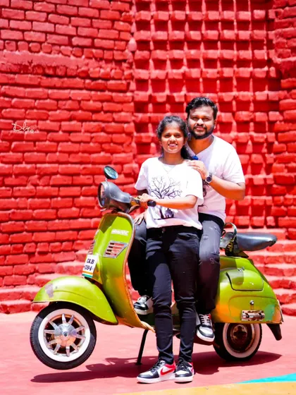 A quirky and fun shot with a vintage green scooter against a bright red brick wall. Props like these add a lot of character to a pre-wedding shoot.