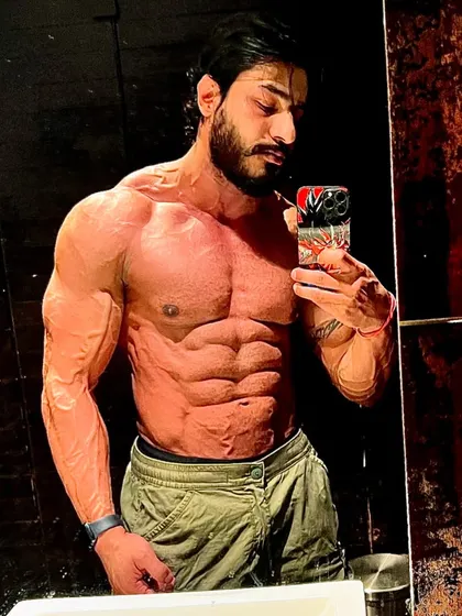 A mirror selfie showing extreme vascularity and a shredded core. This is what a disciplined diet and training plan looks like.