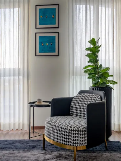 Hello, weekend. This cozy reading nook is the perfect spot to relax. The classic houndstooth armchair with gold accents adds a touch of timeless elegance, complemented by sheer curtains that filter the natural light beautifully.