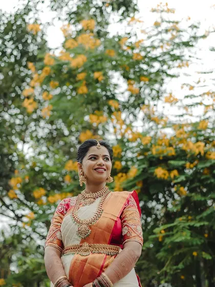 A portrait of Sahana against a beautiful natural backdrop. Her traditional attire and soft makeup create a look of timeless elegance.