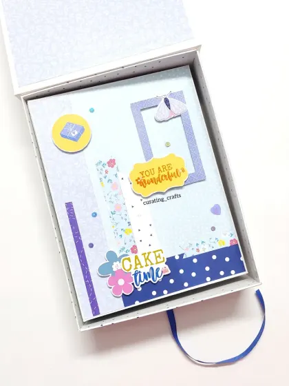 An A5 scrapbook in a protective hard-cover box. This one was a birthday gift for a client's husband, designed with a cheerful and bright color scheme.