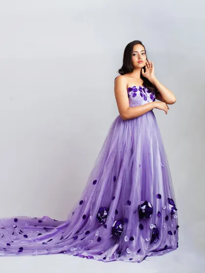 A full-length studio shot of the lavender 3D floral gown against a clean background, highlighting the dress's silhouette and long trail.