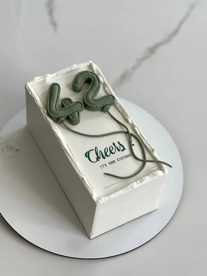 This minimalist balloon number cake in a sophisticated olive green is perfect for a 42nd birthday. It shows how versatile this modern design can be.