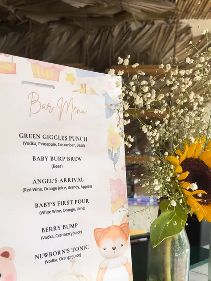 Even the drinks get a cute twist. We designed this custom bar menu with themed drink names like "Green Giggles Punch" and "Baby Burp Brew" for a playful touch.