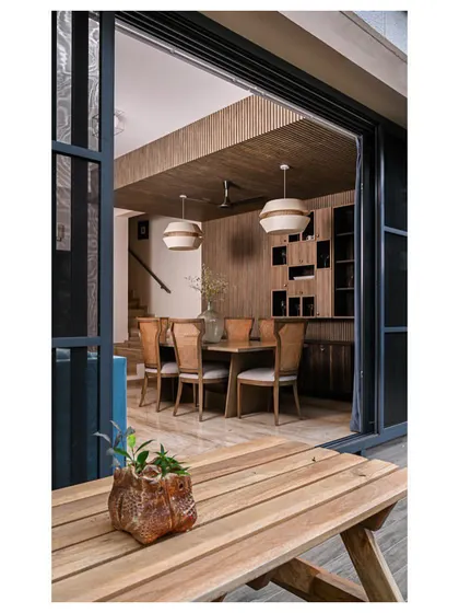A view of the dining room from the balcony, showing how the consistent use of wood creates a seamless indoor-outdoor connection.