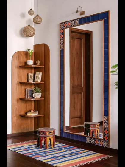 This corner of the master bedroom features a custom-built curved shelving unit and a large mirror framed with blue tiles, creating a simple spot for slow mornings.