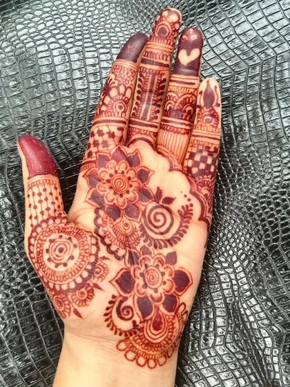 Another angle of the rich henna stain. The deep maroon color contrasts beautifully with the skin, making the floral patterns stand out.