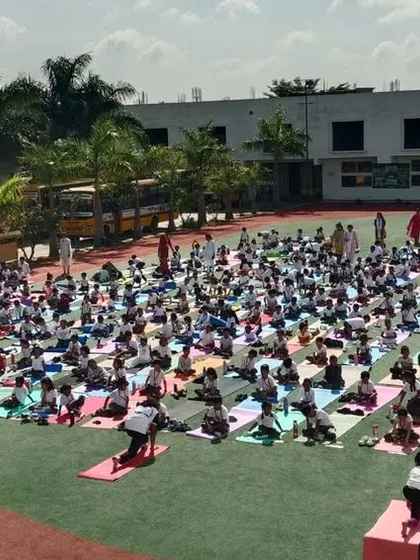 Hundreds of students on colorful yoga mats cover the school field, a powerful visual of our commitment to holistic health and well-being.