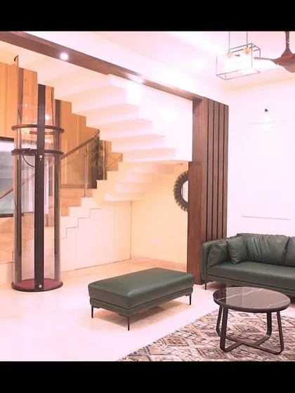 A wide view of the villa's living room, showing the open staircase and the harmonious blend of modern furniture with minimalist wall decor.