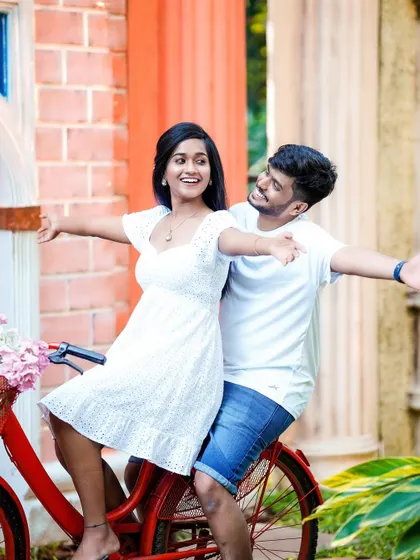 A fun and carefree moment with a couple on a red bicycle.