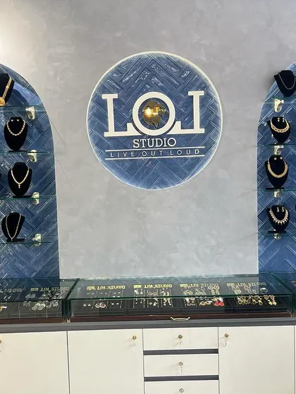 A close-up of our main display wall, featuring a curated selection of our most popular necklace sets. The blue herringbone tile and our studio logo create a distinctive backdrop for the collection.