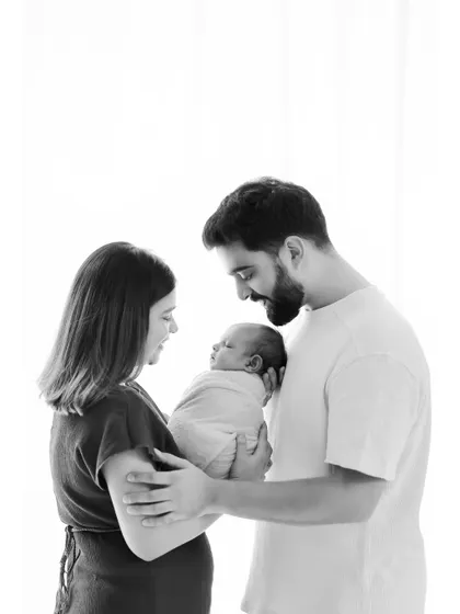 A classic black and white portrait of a new family. This high-contrast image beautifully highlights the emotional connection and the delicate features of the newborn.