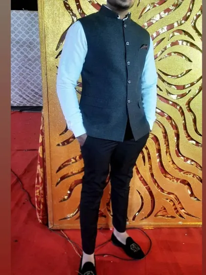 A client looking smart in a dark grey Nehru jacket paired with a light blue shirt and black trousers. This shows how a Nehru jacket can also be styled for a semi-formal look.