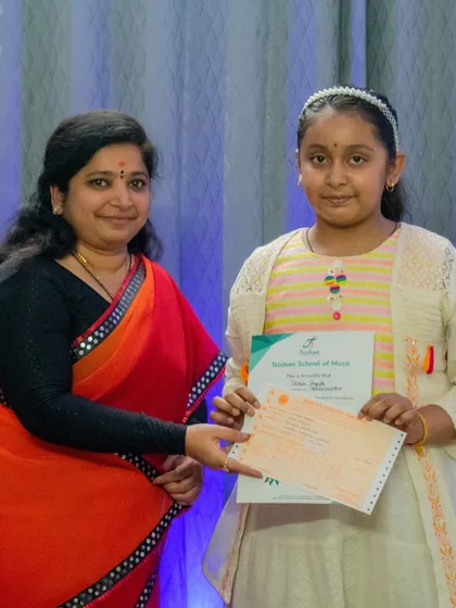 Another proud student receiving her graded exam certificate. Success in these exams demonstrates a solid foundation in music theory and performance.