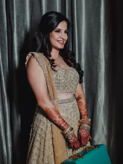 A beautiful portrait of the bride, where the henna stain on her arms complements her glittering lehenga.