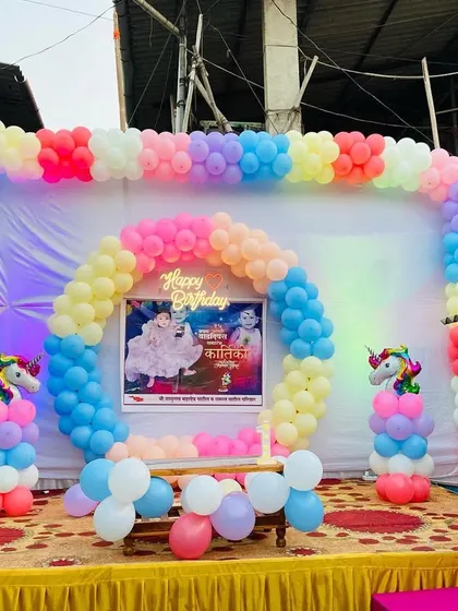 A wider view of the outdoor unicorn birthday party setup, showing the full stage and colorful decorations.