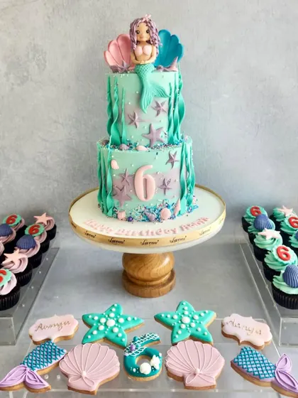 Another take on the mermaid theme, this time with a two-tiered cake and matching cookies and cupcakes. The colours and details bring the under-the-sea party to life.