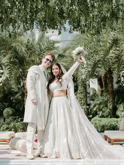 A moment of pure joy as the couple celebrates after their ceremony, showcasing a beautiful cross-cultural wedding.