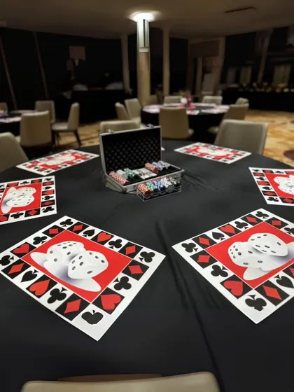 A table set for fun, with custom dice-and-card-suit placemats and a case of poker chips ready for the games to begin.