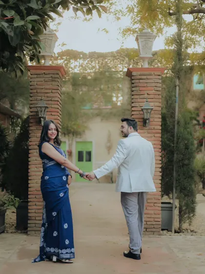 A "follow me to" style shot in a rustic, courtyard-like studio set. This is a popular and fun pose that tells a story of journey and togetherness.