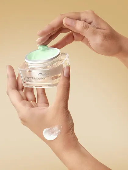 A hand applying a swatch of Natuos 365 Night Cream. Showing the product's texture on the skin is crucial for beauty and skincare e-commerce.