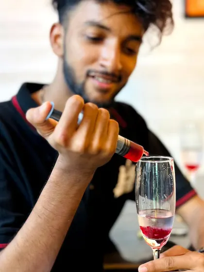 Using a syringe to add a final touch to a layered cocktail. This is part of the precision and fun of our molecular bartending service.