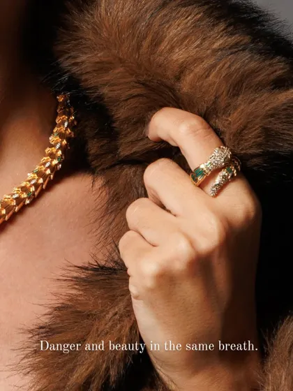 Detail is everything in luxury product photography. Here, the focus shifts to the serpent ring, complementing the necklace. The contrast between the cold metal and the soft fur highlights the piece's danger and beauty in a single frame.