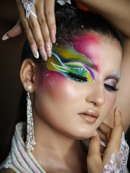 A vibrant, rainbow-inspired fantasy look with glitter and intricate line work.