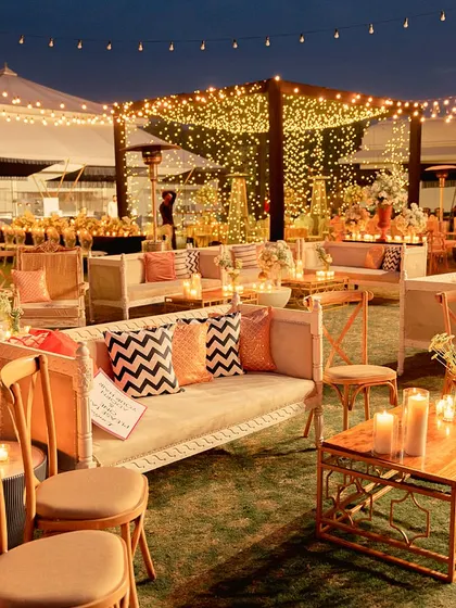 An inviting lounge area under a sky of fairy lights. We used comfortable sofas with modern-print cushions and warm candle lighting to create a perfect space for guests to relax and mingle.