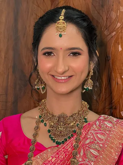 A happy, smiling portrait of Dhwani. Her makeup is radiant and natural, letting her joy be the centerpiece of the look.