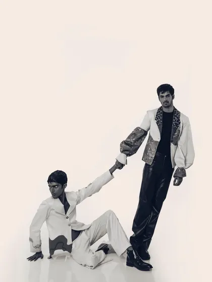 A black and white version of a shot from the "Monsieur" editorial. Stripping away the color highlights the textures and forms of the garments, from the printed sleeves to the sleek leather pants.