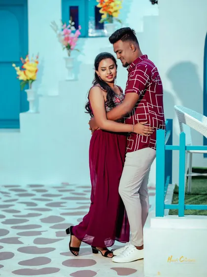 A couple shares a dance in a charming, colorful courtyard with blue and white walls. A sweet, candid moment from a themed pre-wedding shoot.