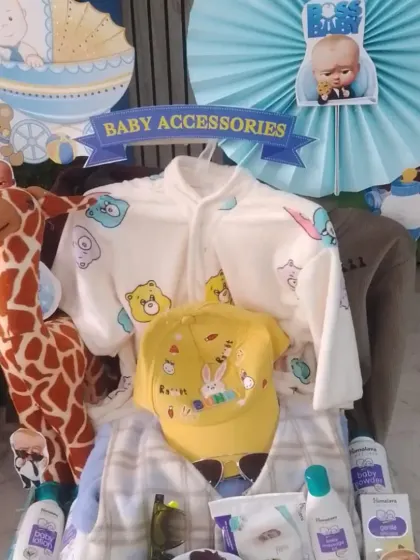 This hamper features a 'Boss Baby' theme and includes a variety of baby products and clothes, with a cute giraffe soft toy.