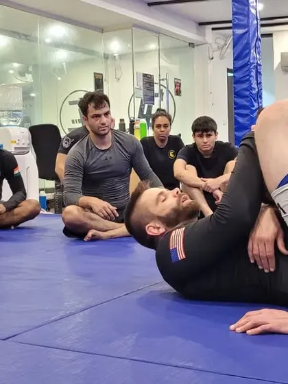 A student practices the triangle choke setup under the watchful eye of the group. We drill, we correct, and we repeat until it's muscle memory.