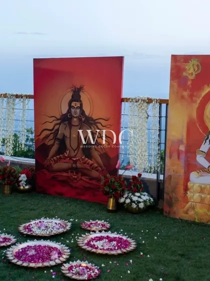 Another corner for the holy rituals, featuring paintings of Hindu deities against the serene backdrop of the mountains, surrounded by fresh flowers.