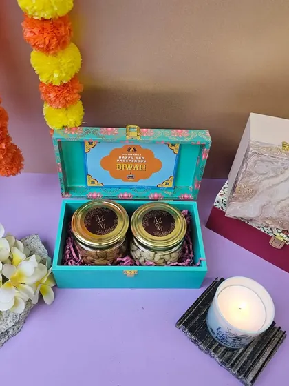 A compact and colorful Diwali gift. This beautiful turquoise box opens to reveal two jars of delicious treats, perfect for a sweet and simple festive greeting.
