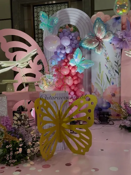 This close-up shows the combination of iridescent butterfly balloons, 3D paper butterflies, and balloon clusters that add texture and magic to the backdrop.