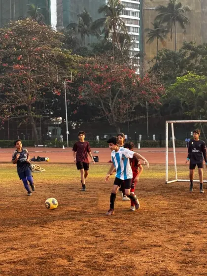 A player dribbles the ball during a practice match, showcasing the skills learned during our professional football coaching. We focus on building a strong foundation of discipline and passion for the sport.