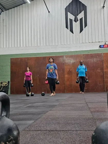 A different view of our members during a kettlebell carry workout. We focus on maintaining an upright posture and a strong core throughout the movement.