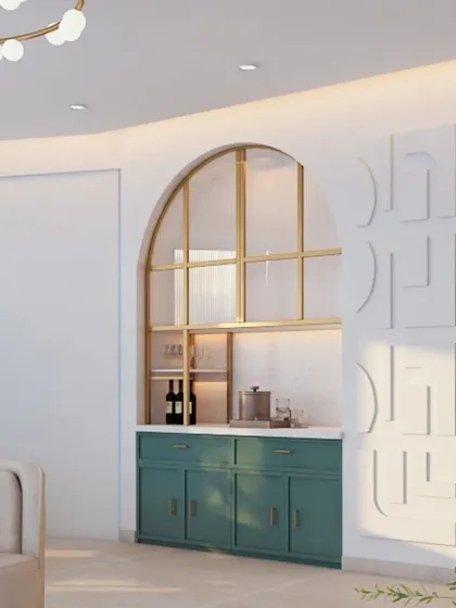 A beautiful built-in bar designed within an archway. The green cabinets, brass-framed glass doors, and white countertop create a fresh and elegant look.