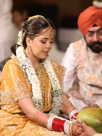 The bride participating in wedding rituals, her traditional hairstyle holding strong.