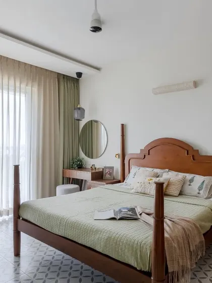 A wide shot of the bedroom, showing the four-poster bed, integrated dressing table, and the light, airy feel created by the sheer curtains.