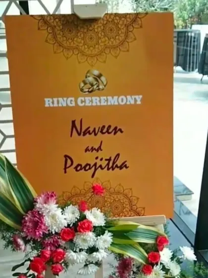 A custom welcome sign for a ring ceremony with a vibrant orange and floral design.