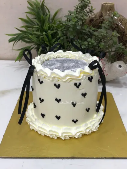 A chic glitter cake with black hearts and delicate black ribbon bows. This design is simple, modern, and perfect for a stylish birthday or bachelorette party.
