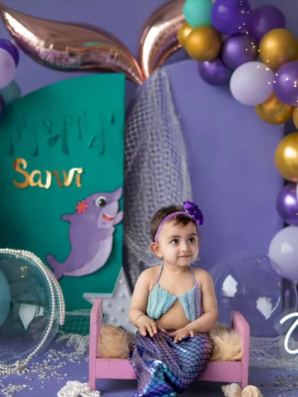 Our little mermaid posing on her pink throne. We have multiple props and outfits to create a variety of looks within a single themed session.