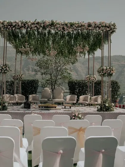 A minimalist Vidhi Mandap set against a stunning mountain backdrop. The design uses clean lines and hanging florals to enhance, not obstruct, the natural beauty of the venue.