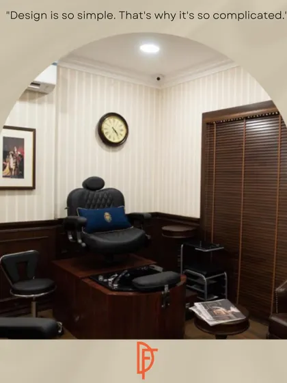 Every detail in the salon is considered, right down to the styling stations. This image shows a private grooming station with a classic leather barber chair, wood paneling, and pinstripe wallpaper, creating a space that feels both professional and comfortable.